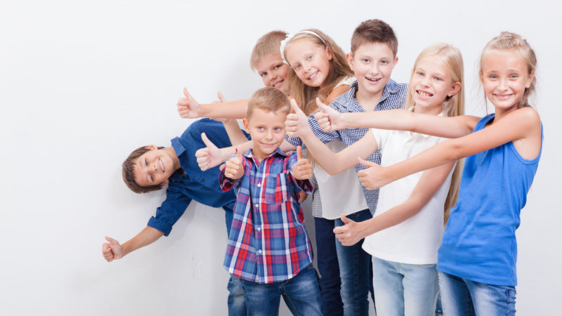 The smiling teenagers showing okay sign on white background.